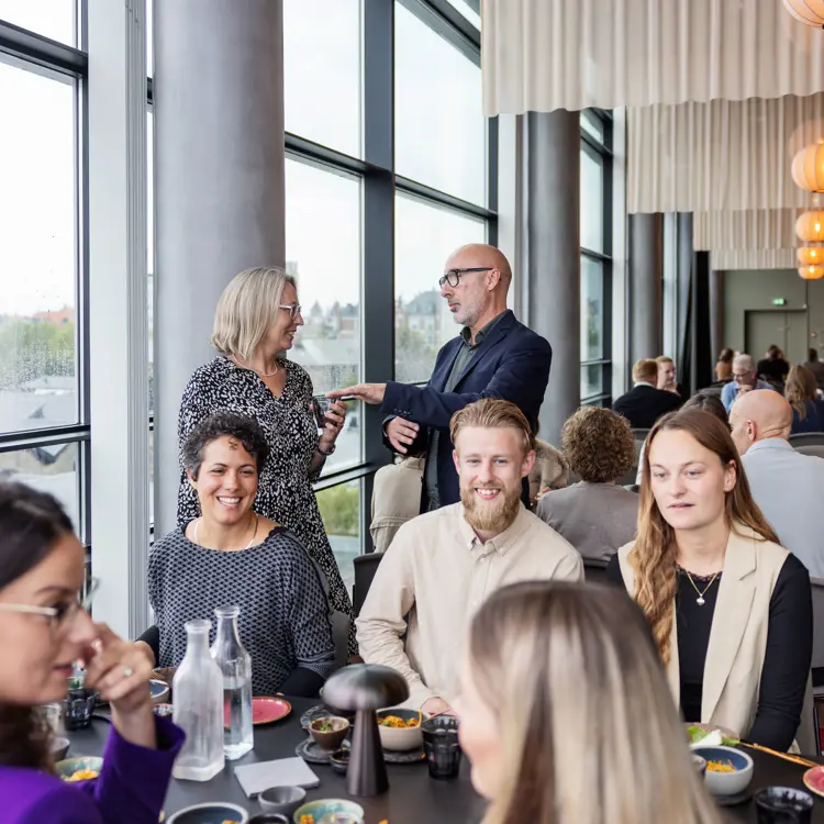 En gruppe mødegæster der taler til frokost