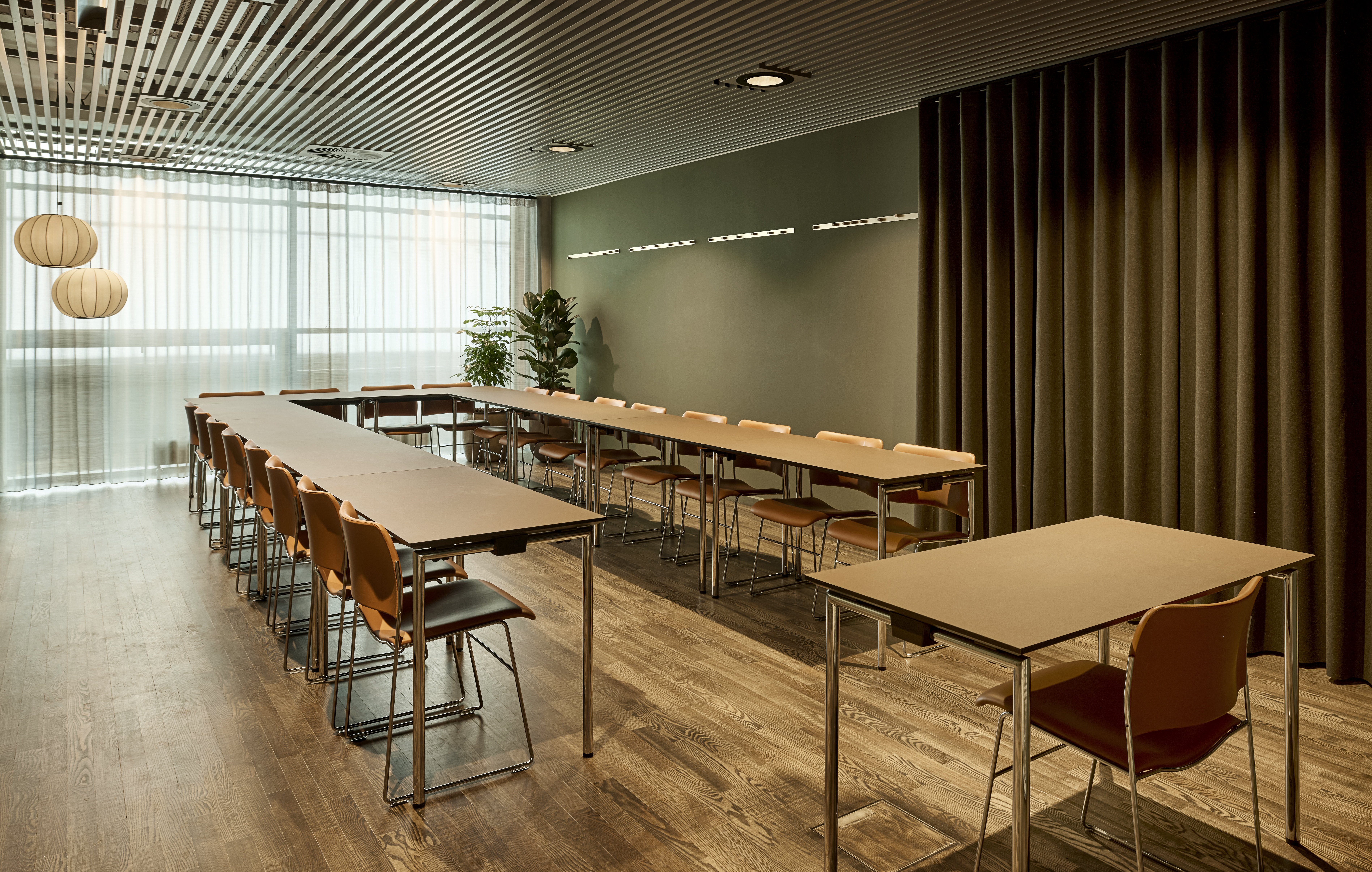 Et lyst mødelokale med en bordopsætning 