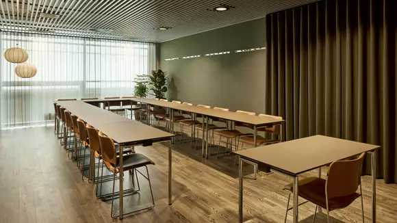 Et lyst mødelokale med en bordopsætning