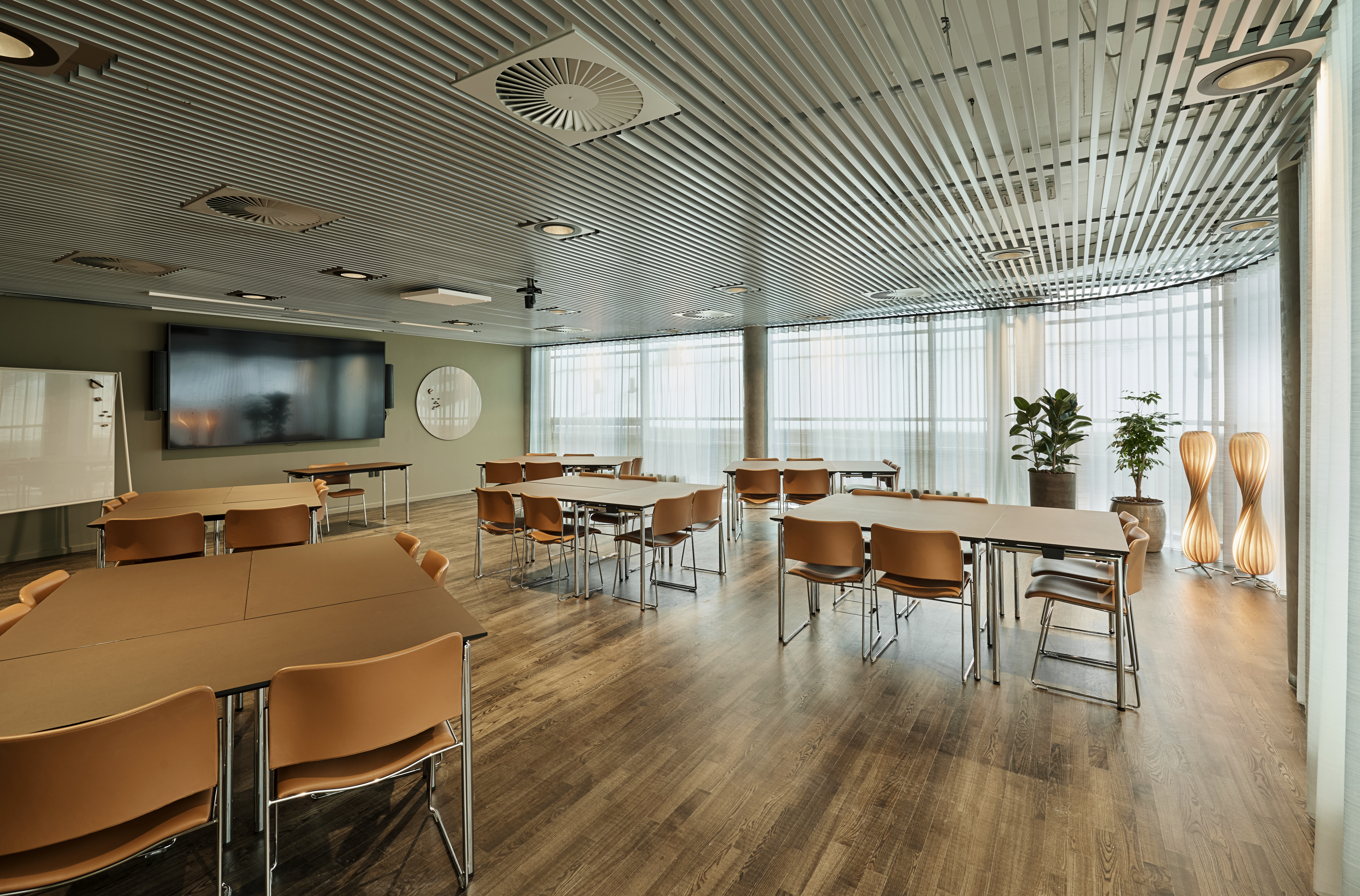 Et lyst mødelokale med en bordopsætning 