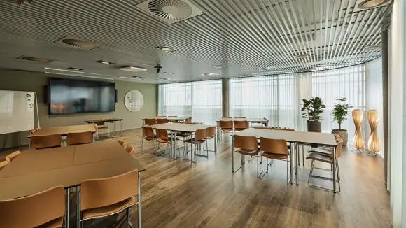 Et lyst mødelokale med en bordopsætning