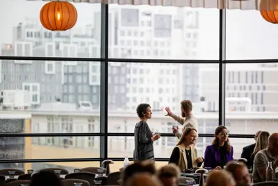 To mødegæster står og taler mens de kigger på udsigten fra Restaurant Østerbro