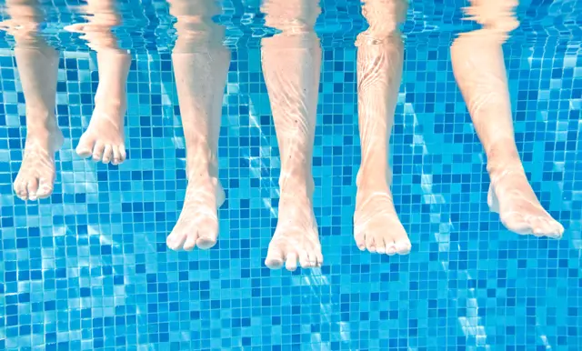 Barn i rød badering i pool