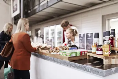 A conference guest placing an order in the café at Øksnehallen