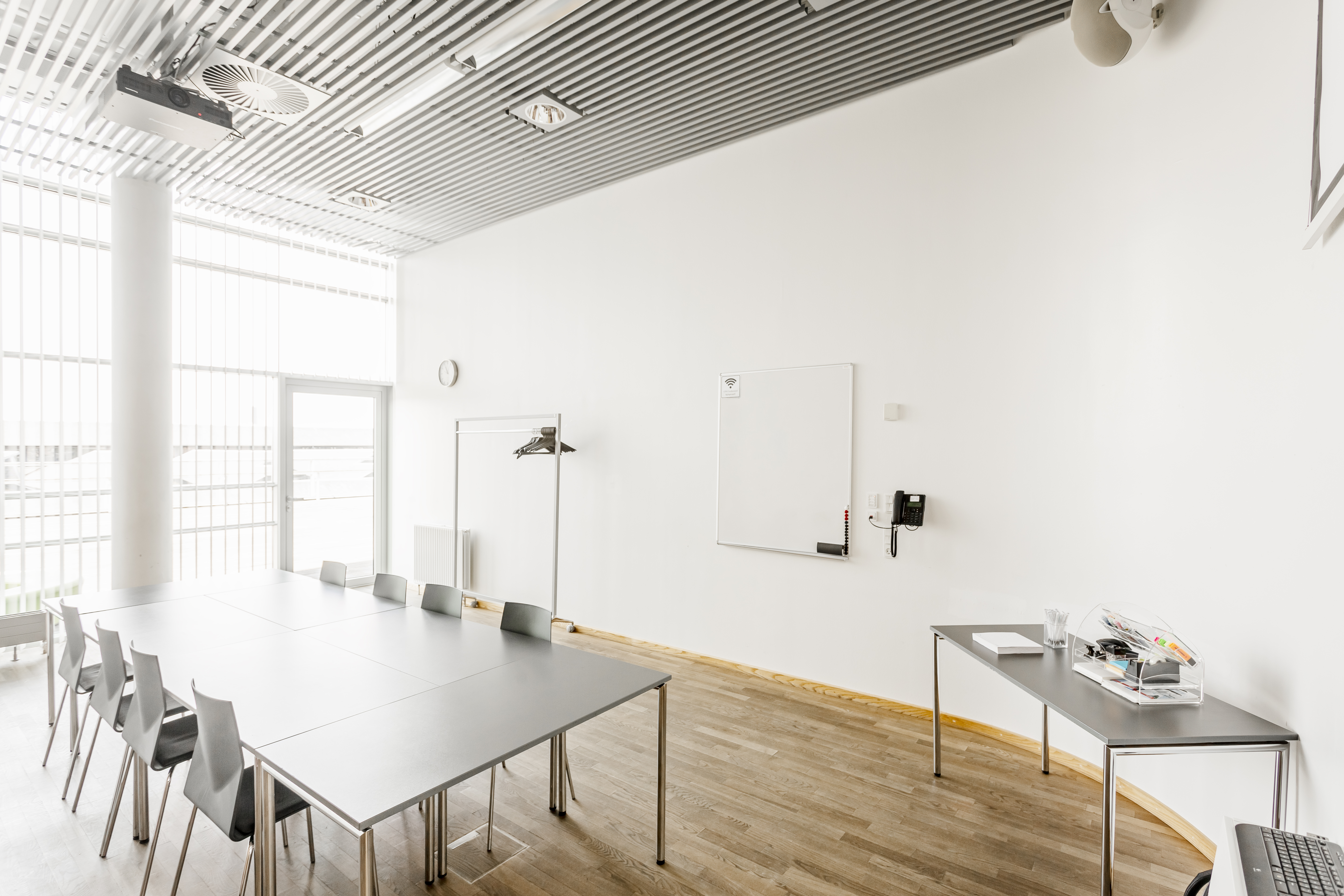Et lyst mødelokale med en bordopsætning 