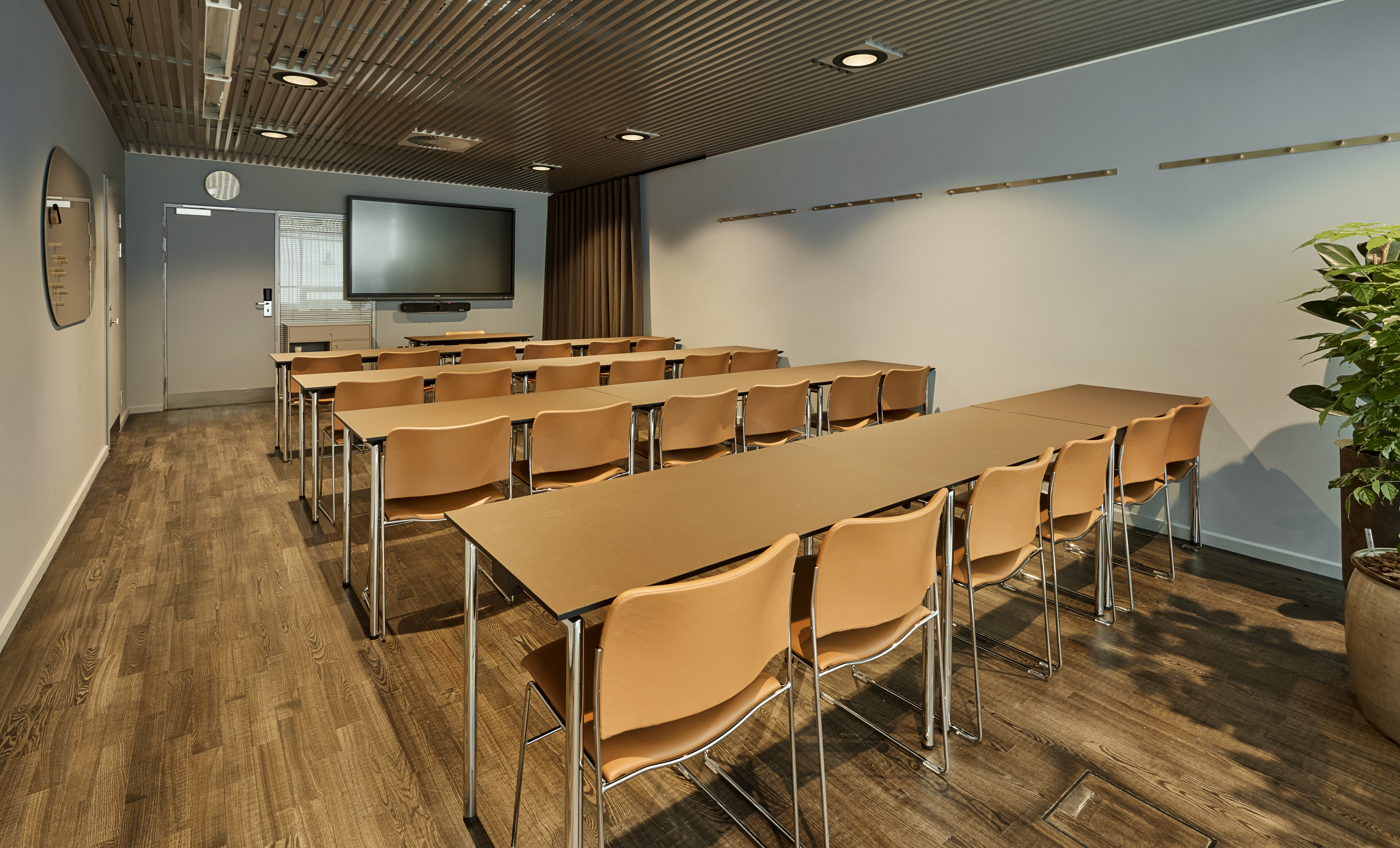 Et lyst mødelokale med en bordopsætning 