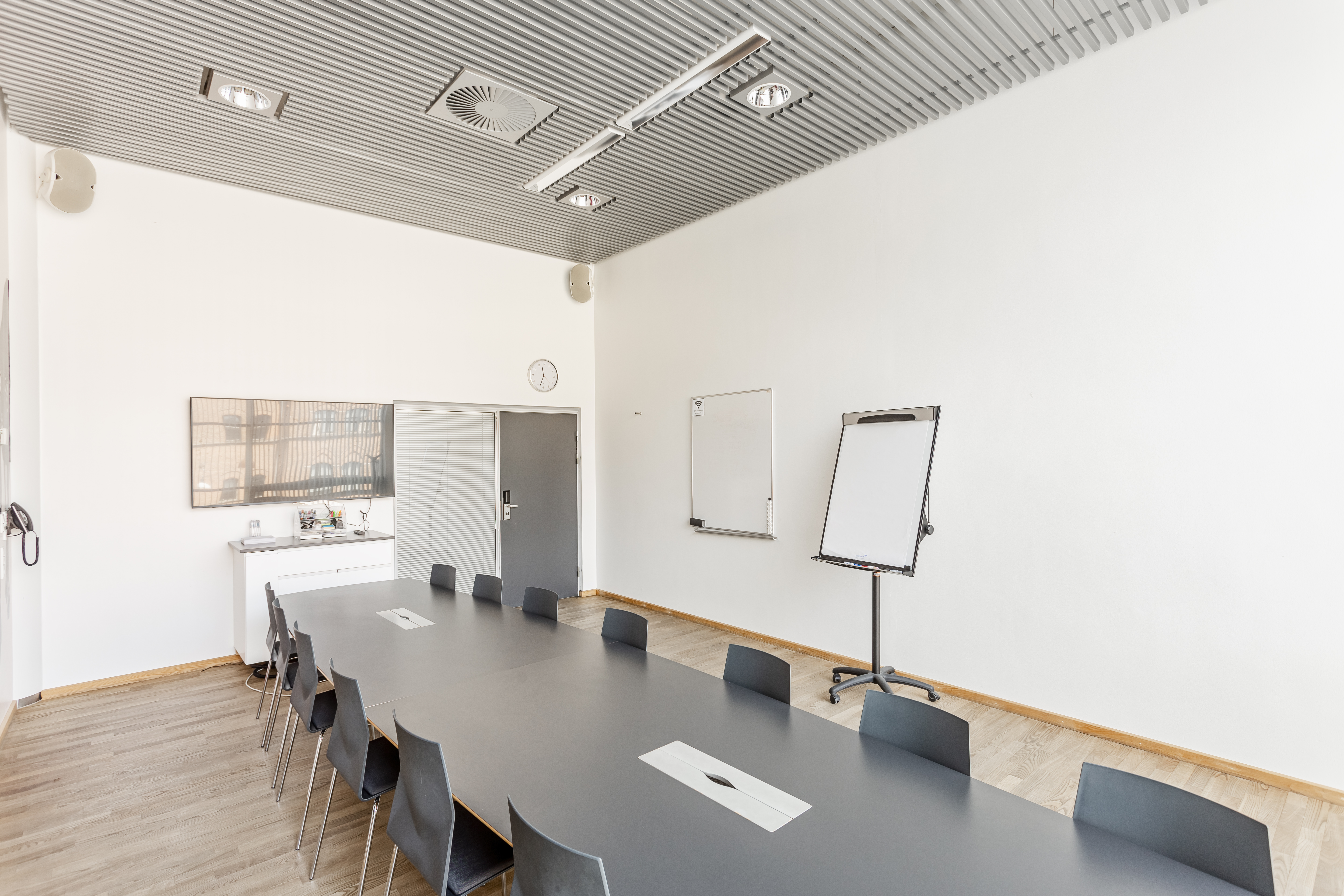 Et lyst mødelokale med en bordopsætning 