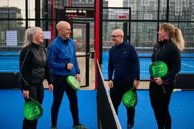 En gruppe kolleger der taler efter padel