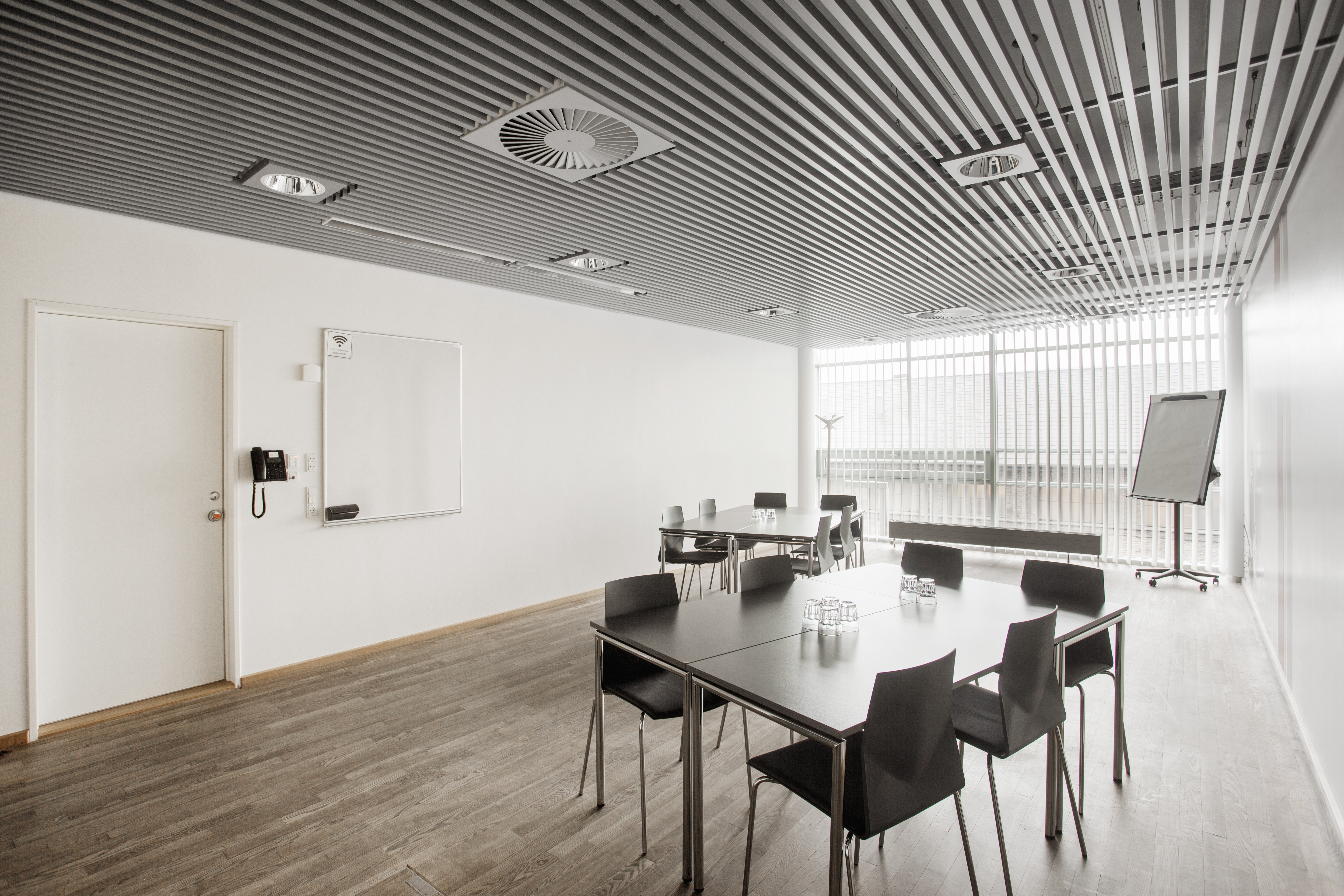 Et lyst mødelokale med en bordopsætning 