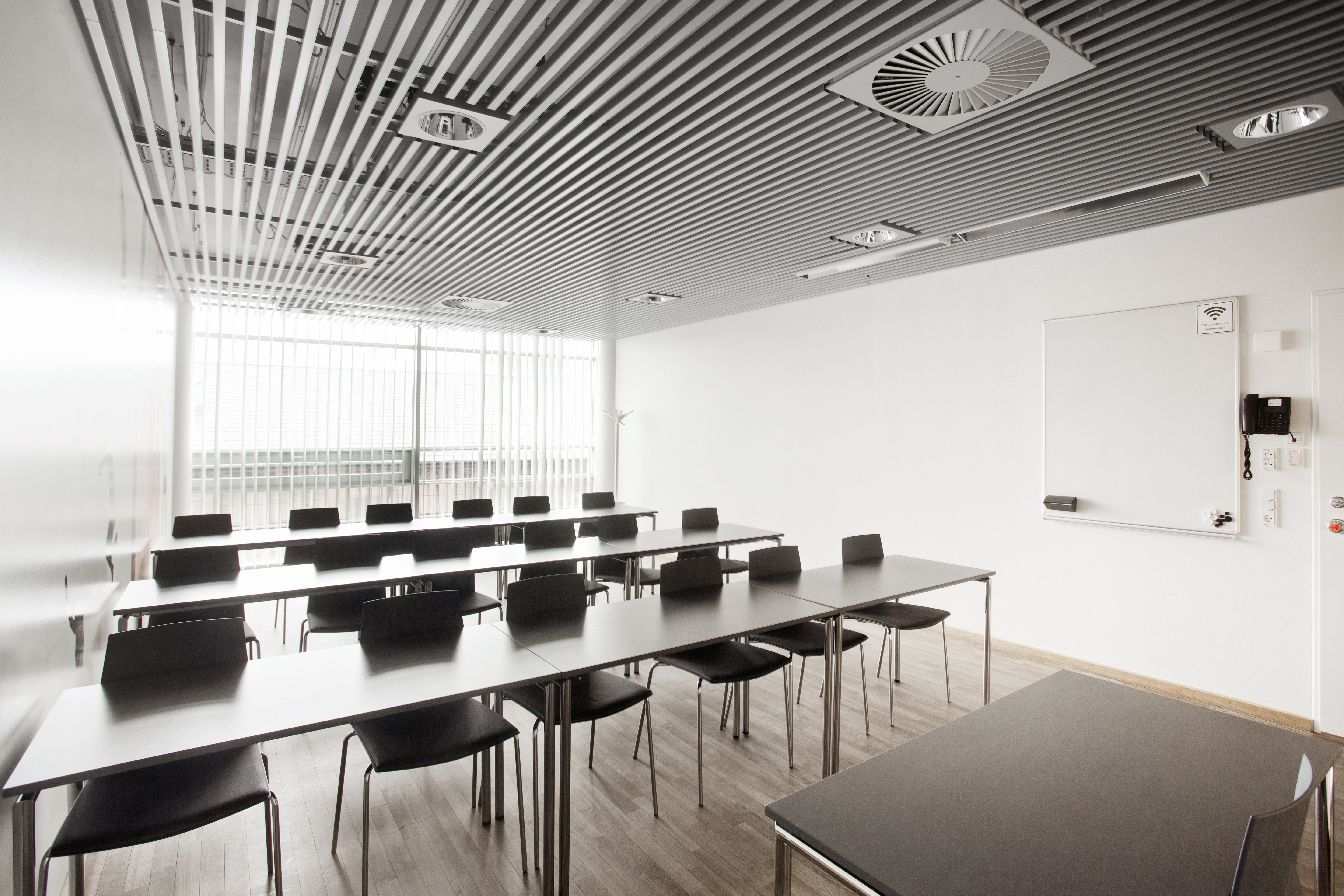 Et lyst mødelokale med en bordopsætning 