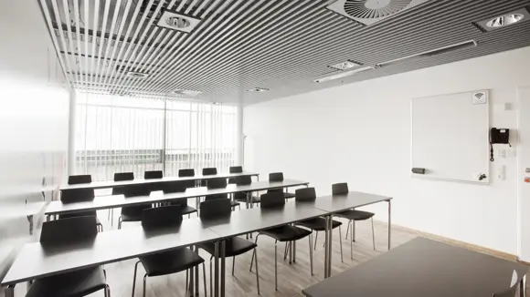 Et lyst mødelokale med en bordopsætning