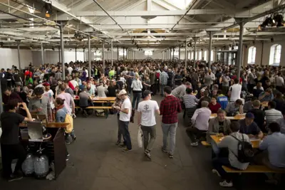 A large group of people sitting at bench tables in Øksnehallen