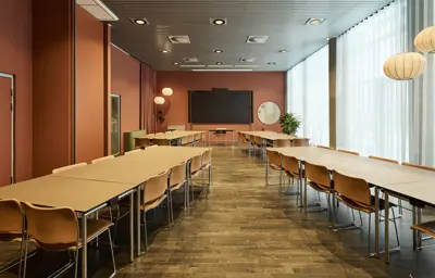 Et lyst mødelokale med en bordopsætning