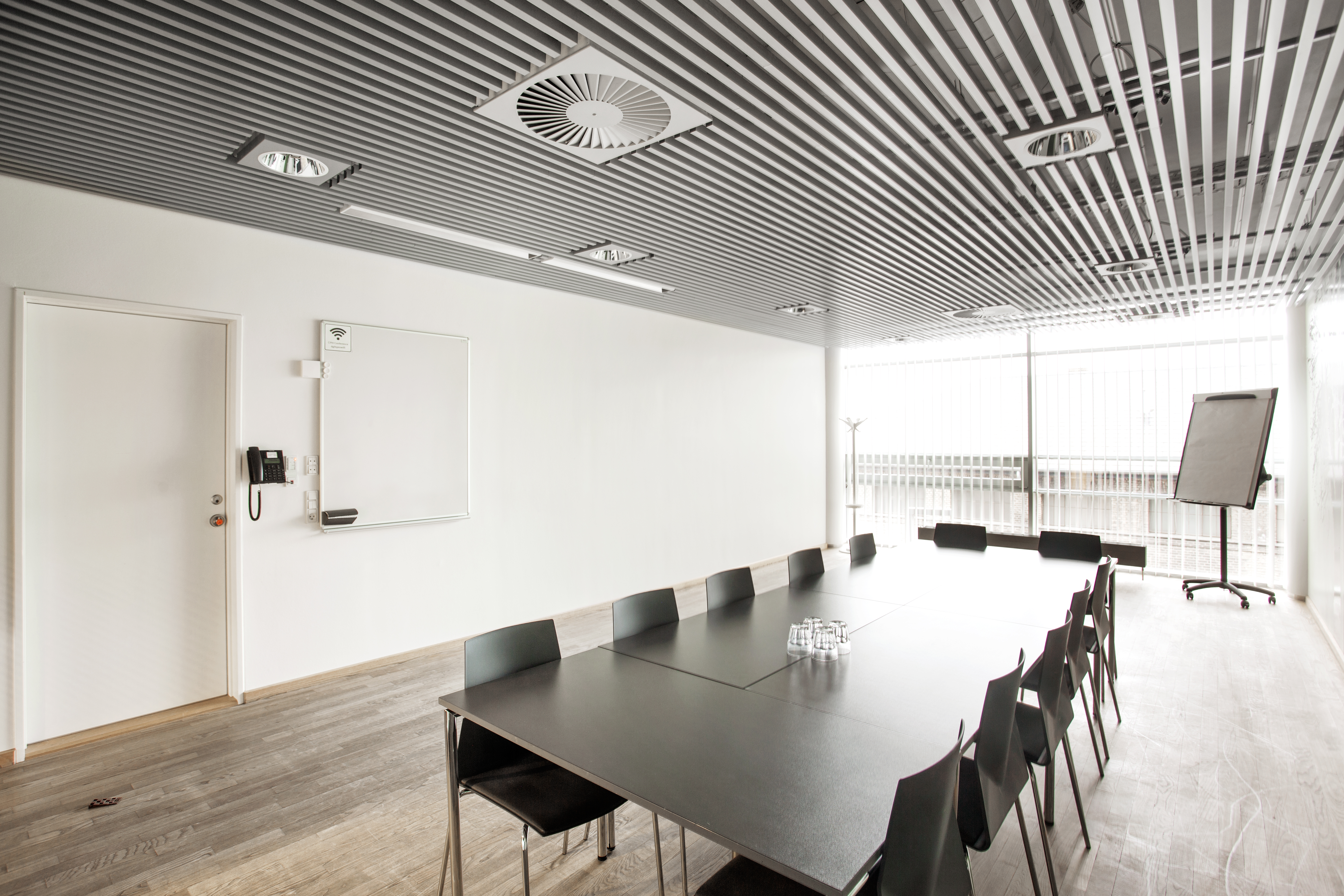 Et lyst mødelokale med en bordopsætning 