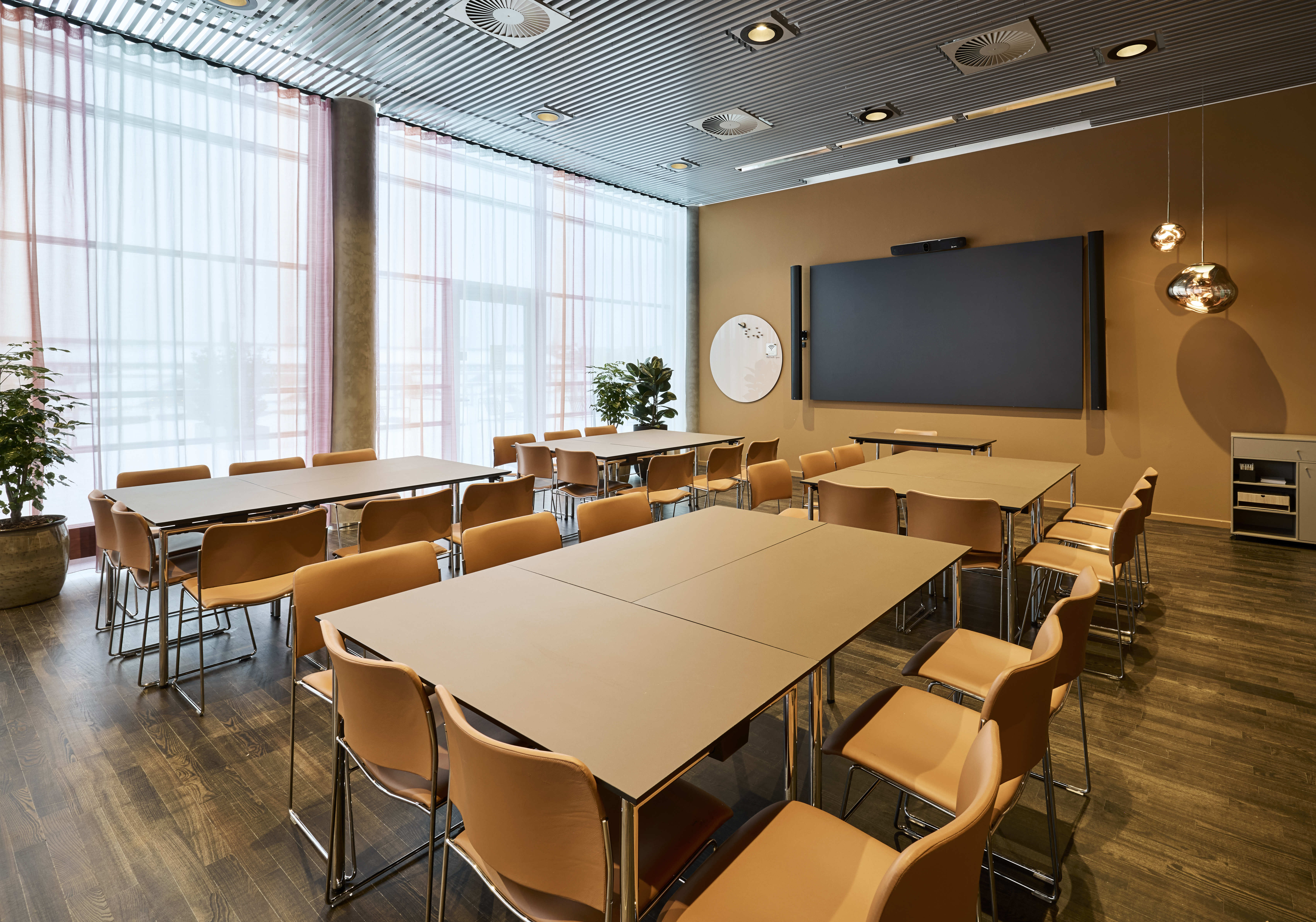 Et lyst mødelokale med en bordopsætning 