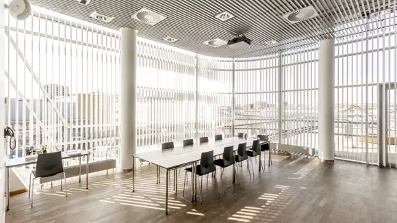 Et lyst mødelokale med en bordopsætning