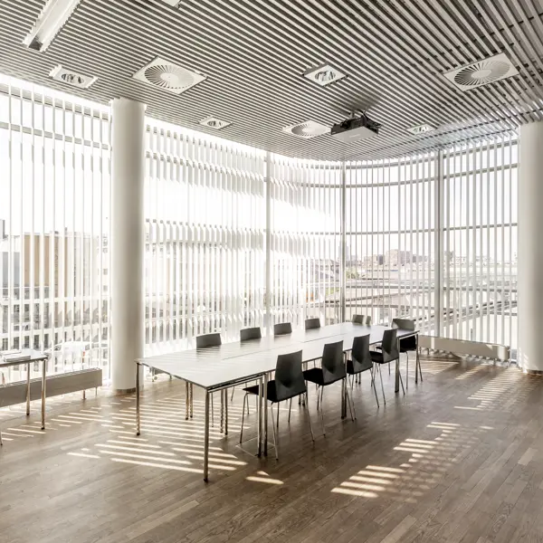 Et lyst mødelokale med en bordopsætning