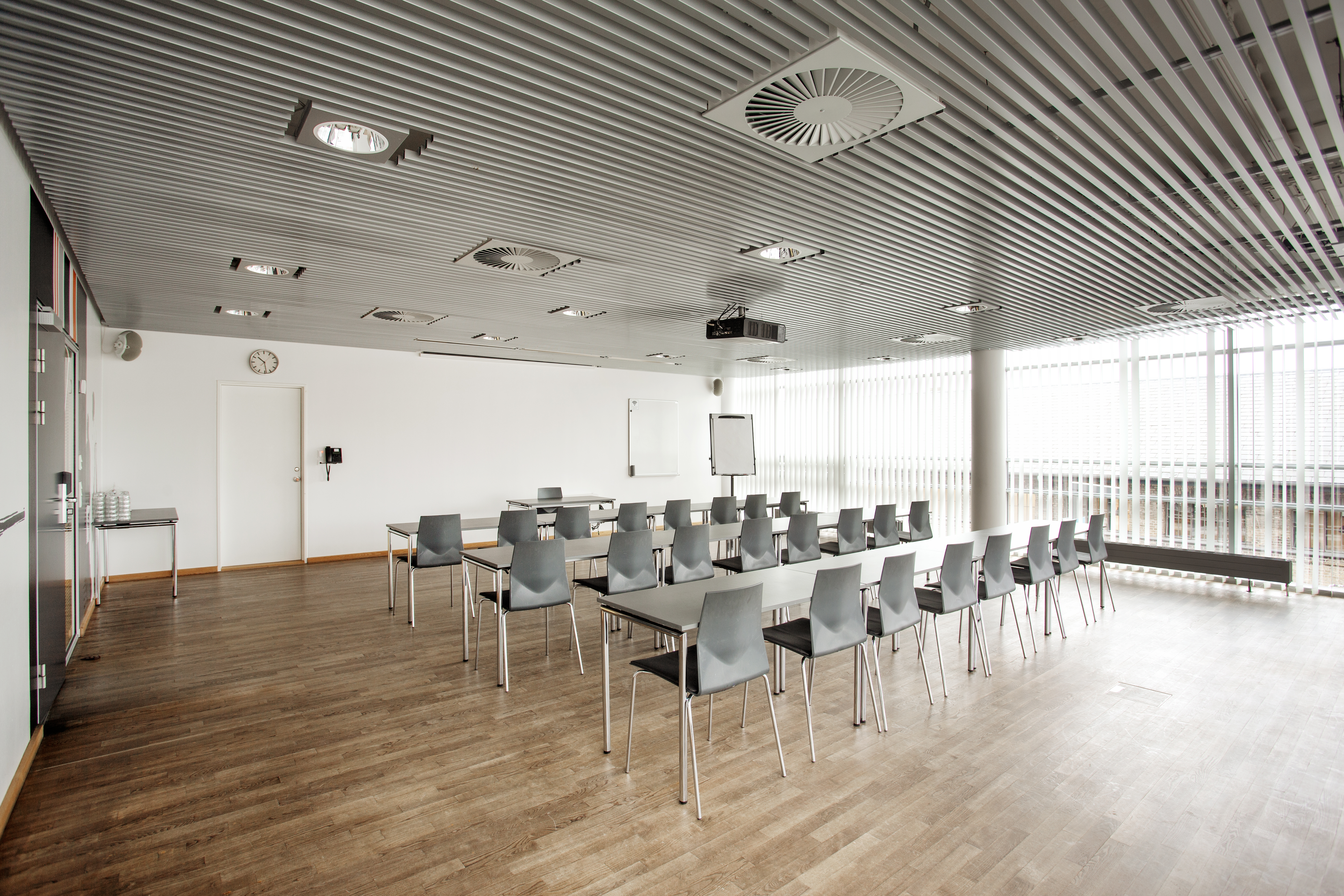 Et lyst mødelokale med en bordopsætning 