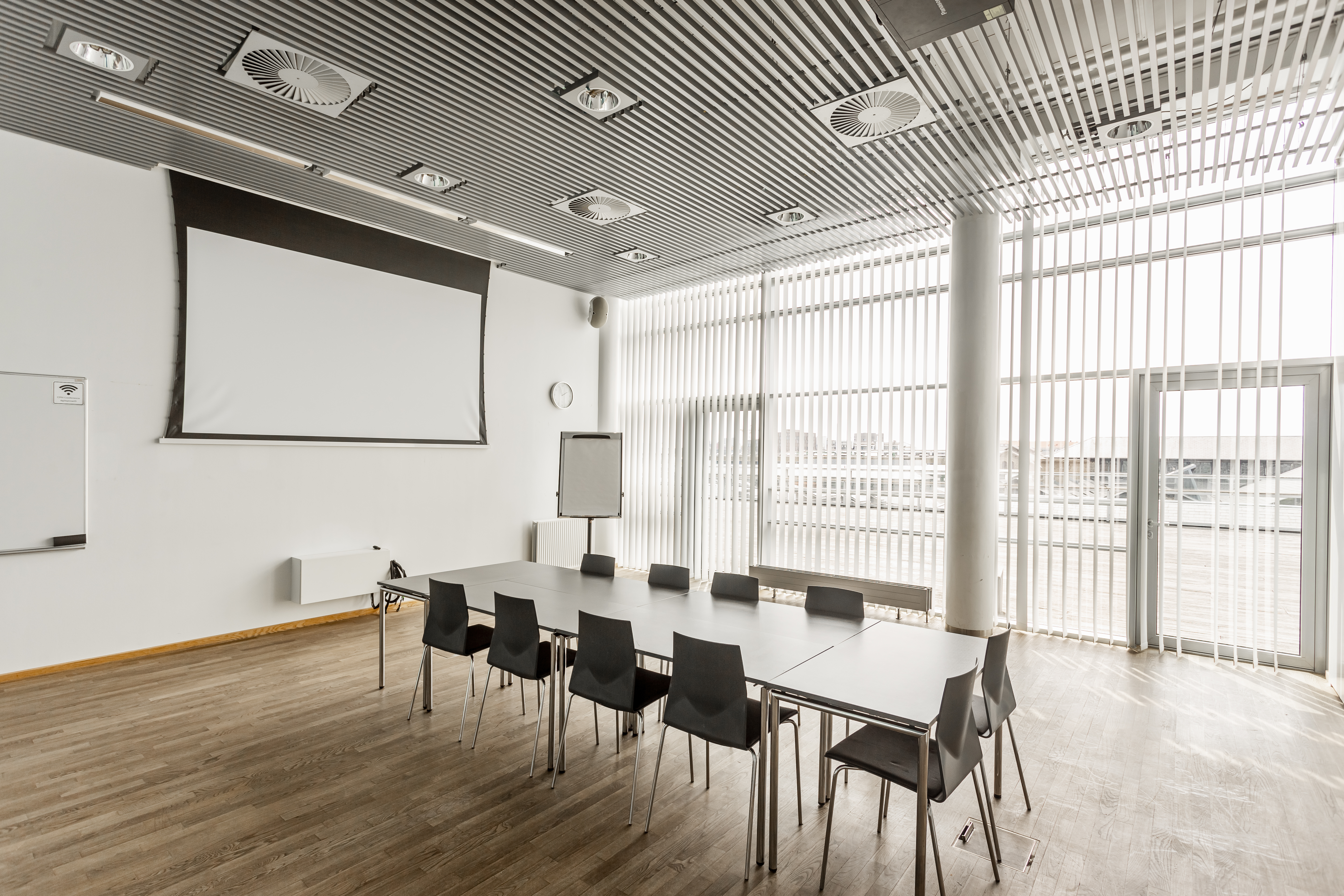 Et lyst mødelokale med en bordopsætning 