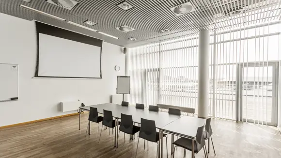 Et lyst mødelokale med en bordopsætning