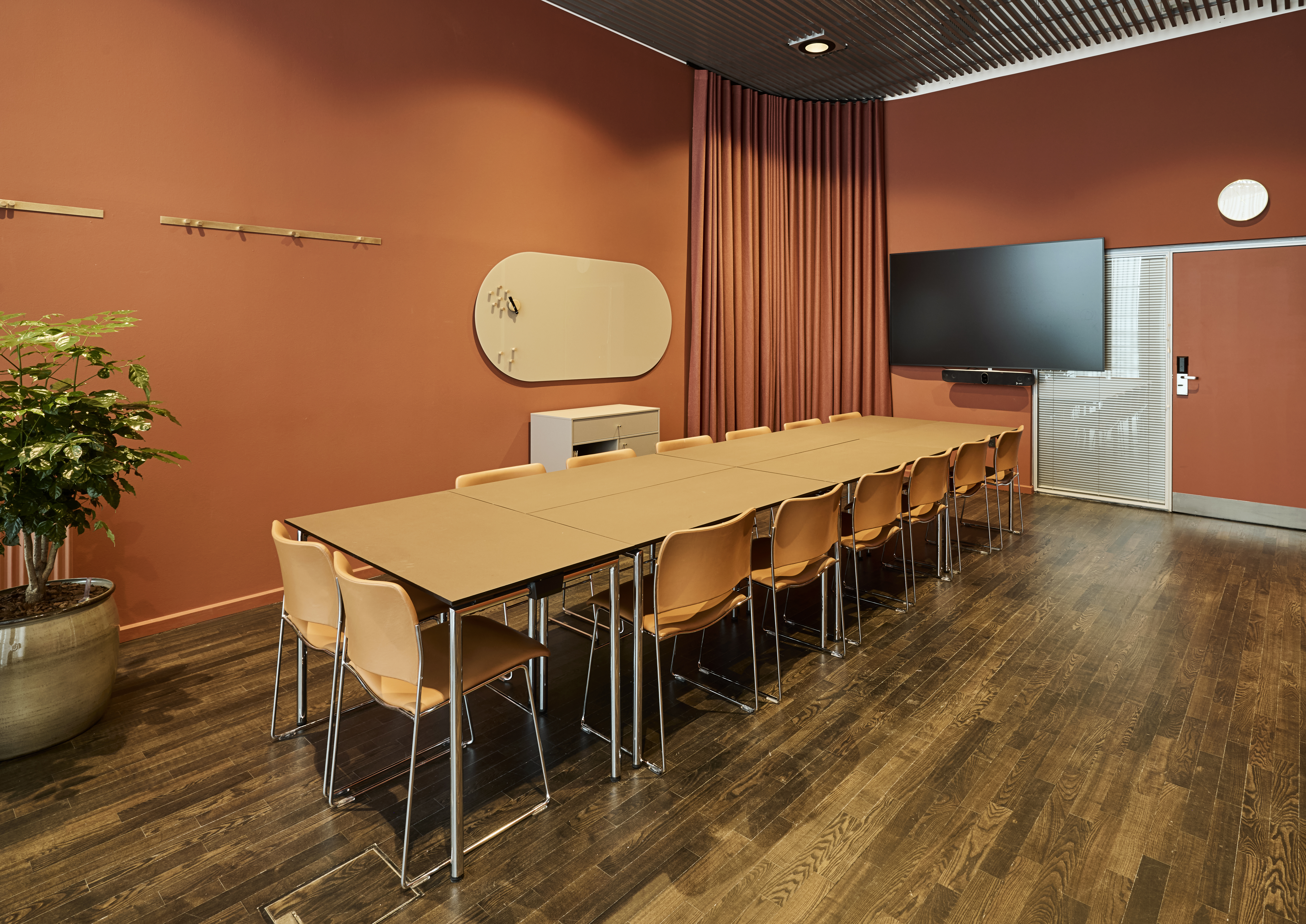 Et lyst mødelokale med en bordopsætning 