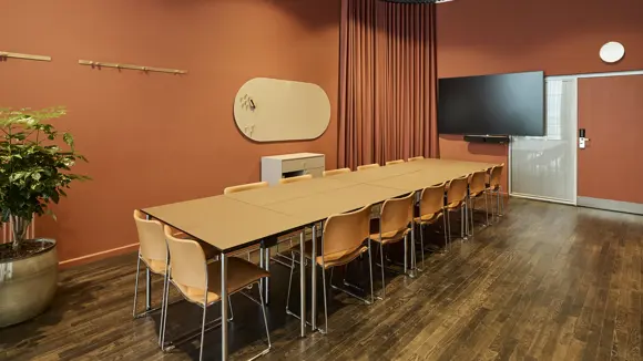 Et lyst mødelokale med en bordopsætning