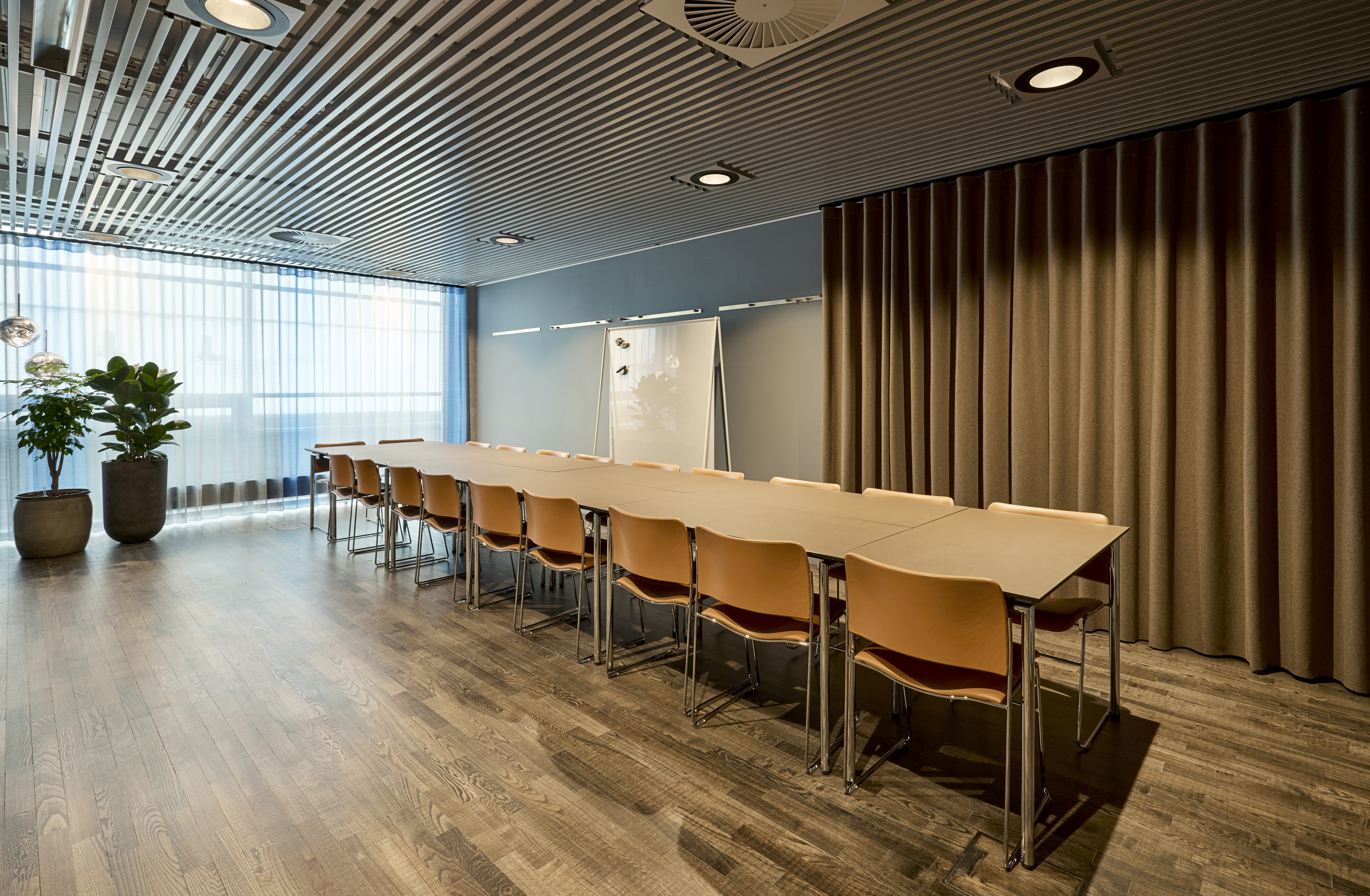 Et lyst mødelokale med en bordopsætning 