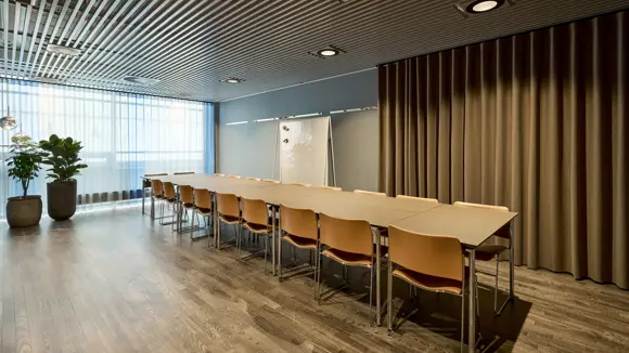 Et lyst mødelokale med en bordopsætning