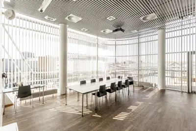 Et lyst mødelokale med en bordopsætning