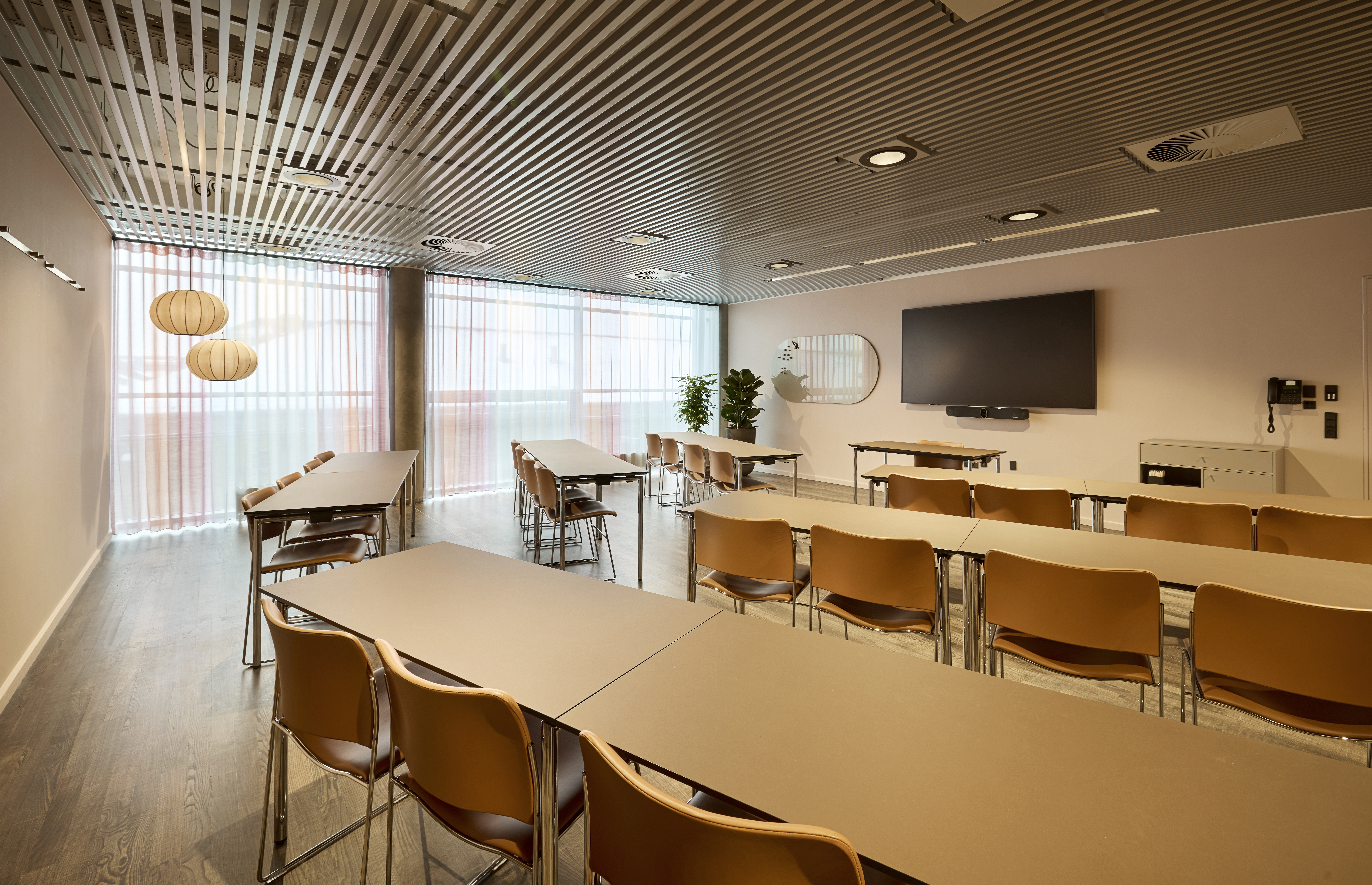 Et lyst mødelokale med en bordopsætning 