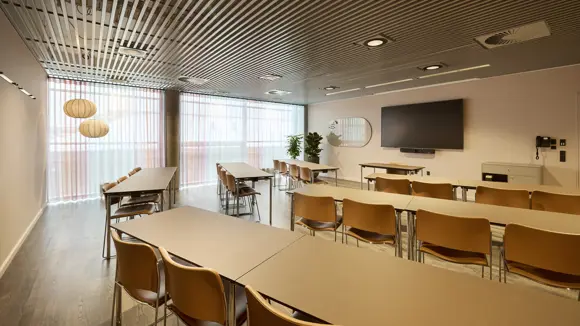 Et lyst mødelokale med en bordopsætning