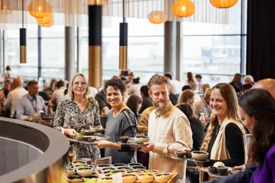 En gruppe mødegæster der henter mad i buffeten