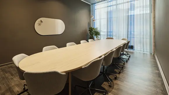 Et lyst mødelokale med en bordopsætning