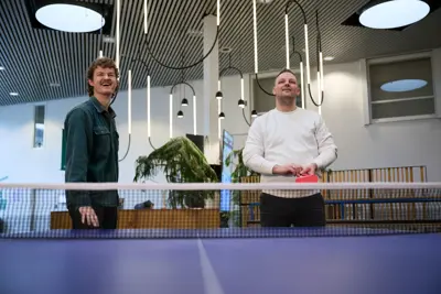 Two people playing doubles table tennis
