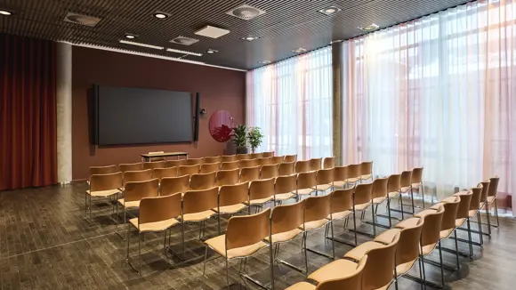 Et lyst mødelokale med en bordopsætning