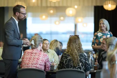 En vært der står og introducerer mødegæster for menuen