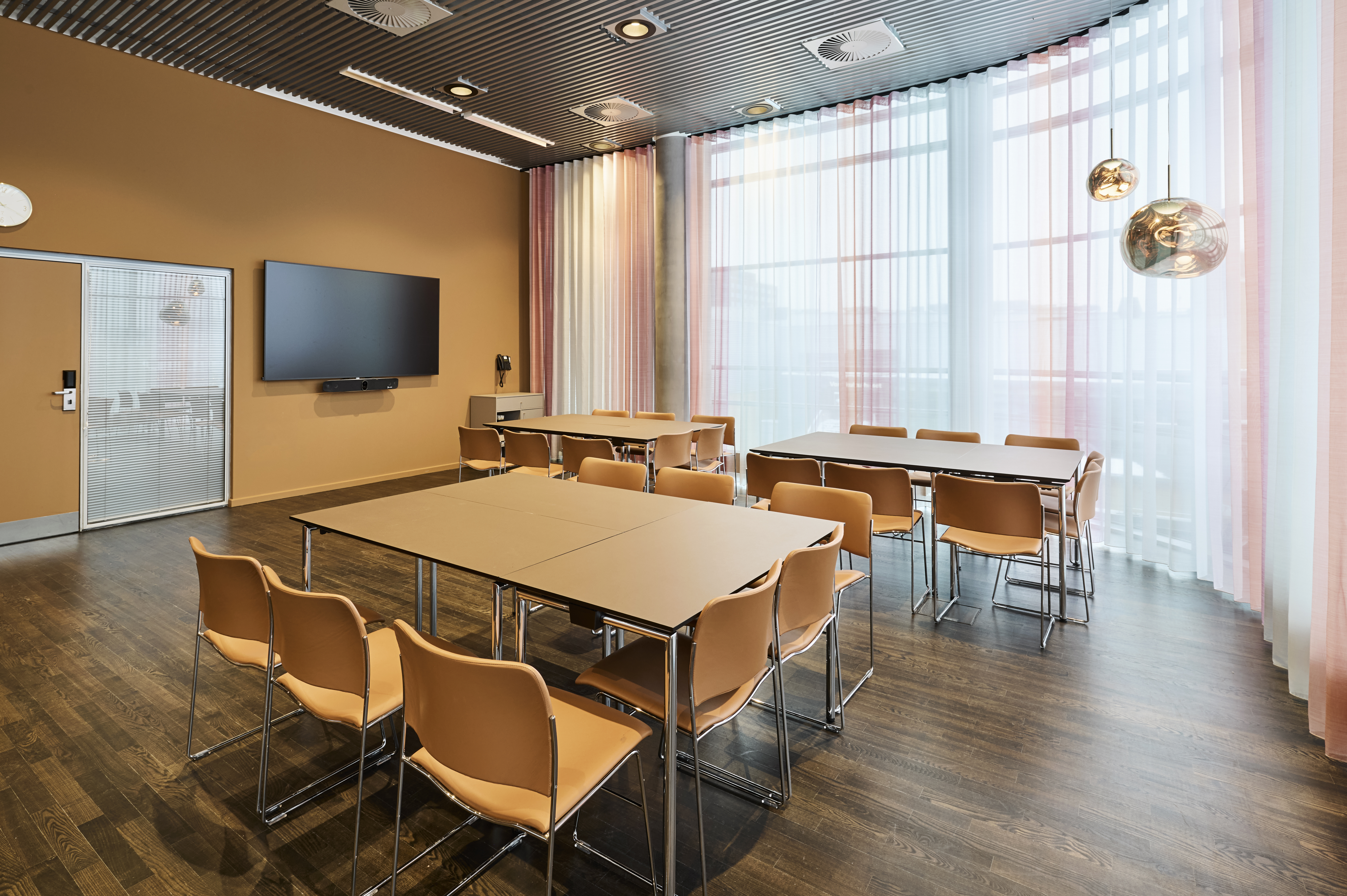 Et lyst mødelokale med en bordopsætning 